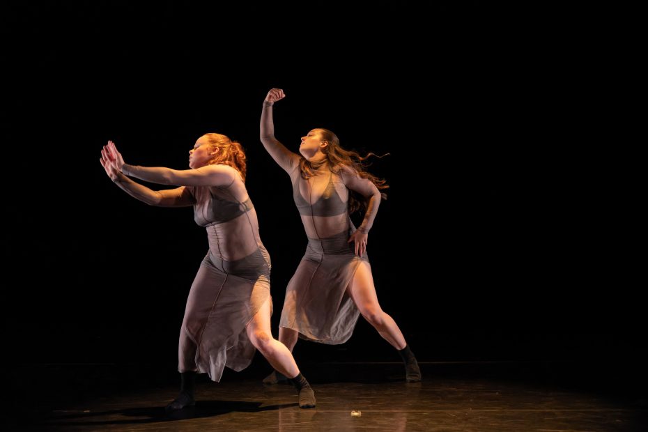 2 dancers against a black background