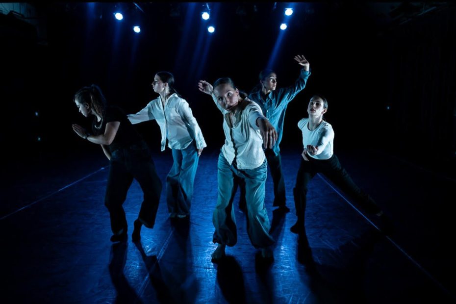 CERBERUS dancers wearing white shirts against a black background