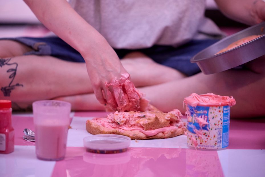 kelly's hands in pink frosting put it atop an ugly funfetti cake