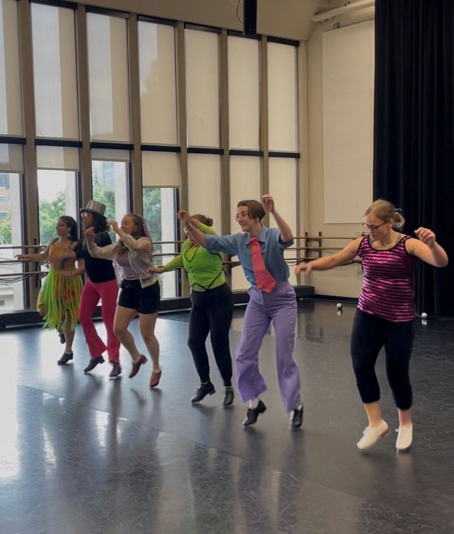 Rain City Tappers dressed in colorful garments in studio at UW