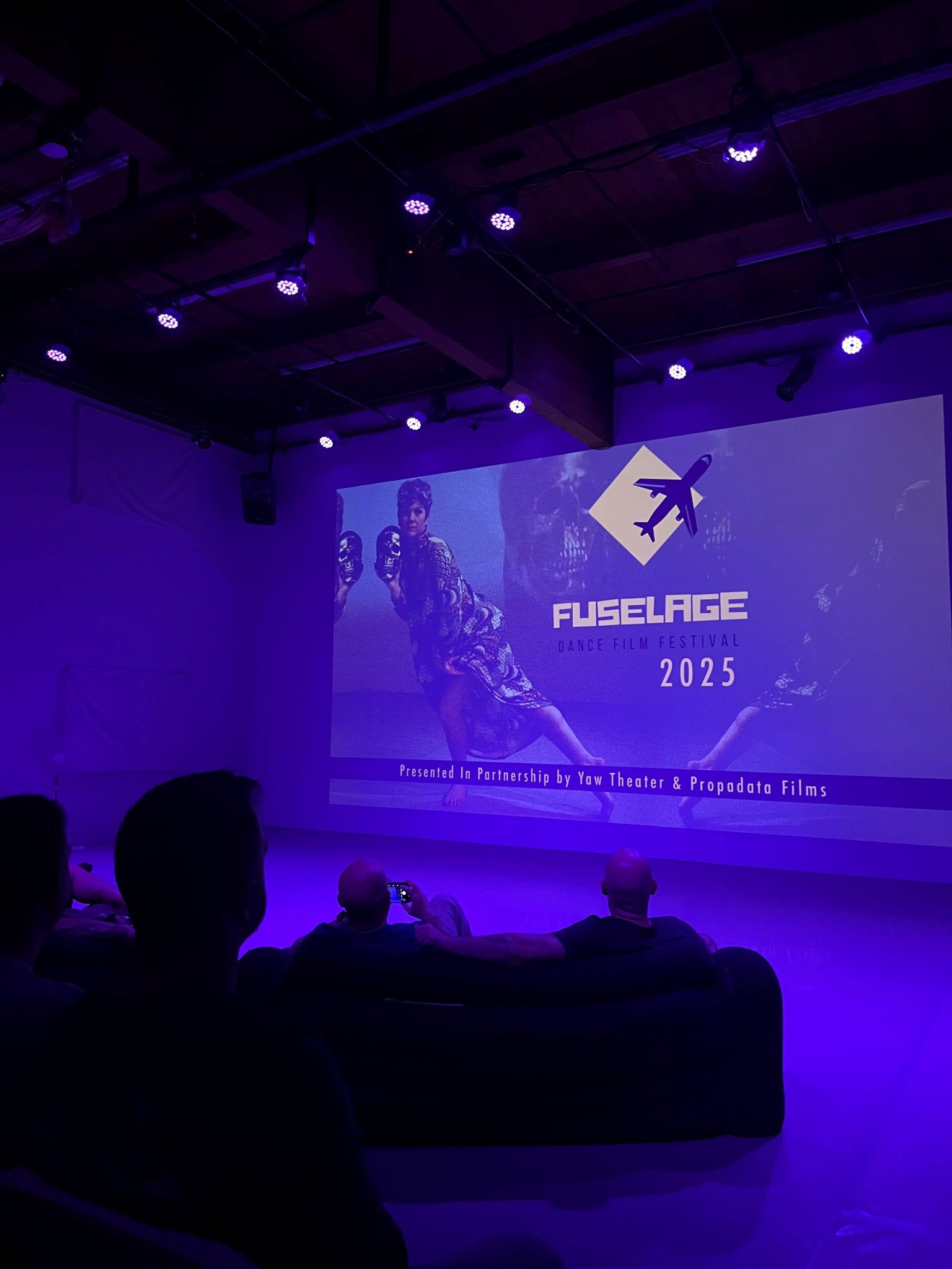 Fusalage video projected on a screen in purple and blue