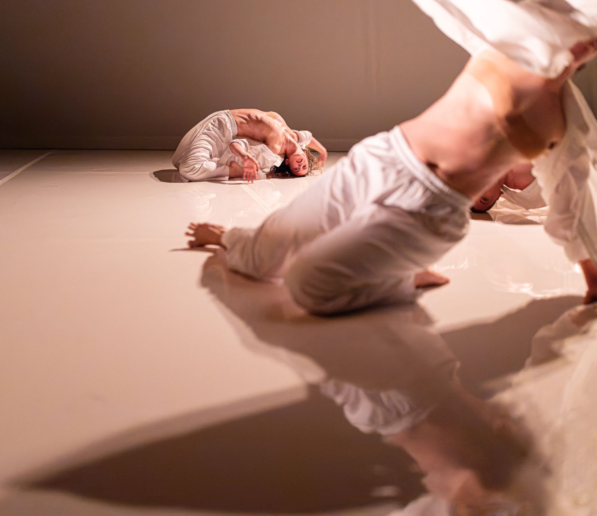 d’urfe piece with dancers wearing white against a white background
