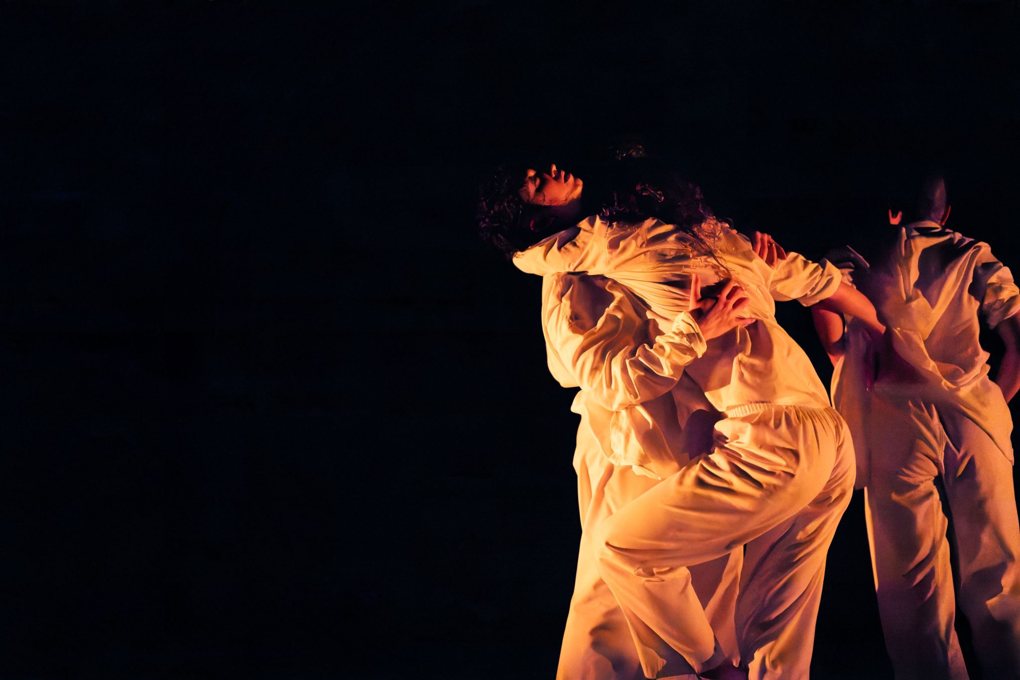 d’urfe pieces with dancers wearing white against a black background