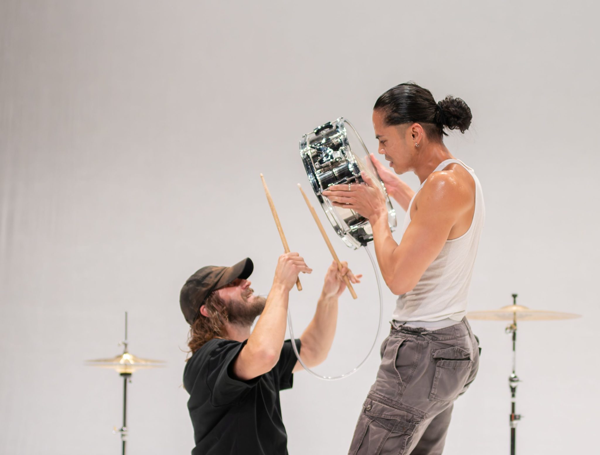 Jobel holding a snare drum with drummer in black shirt