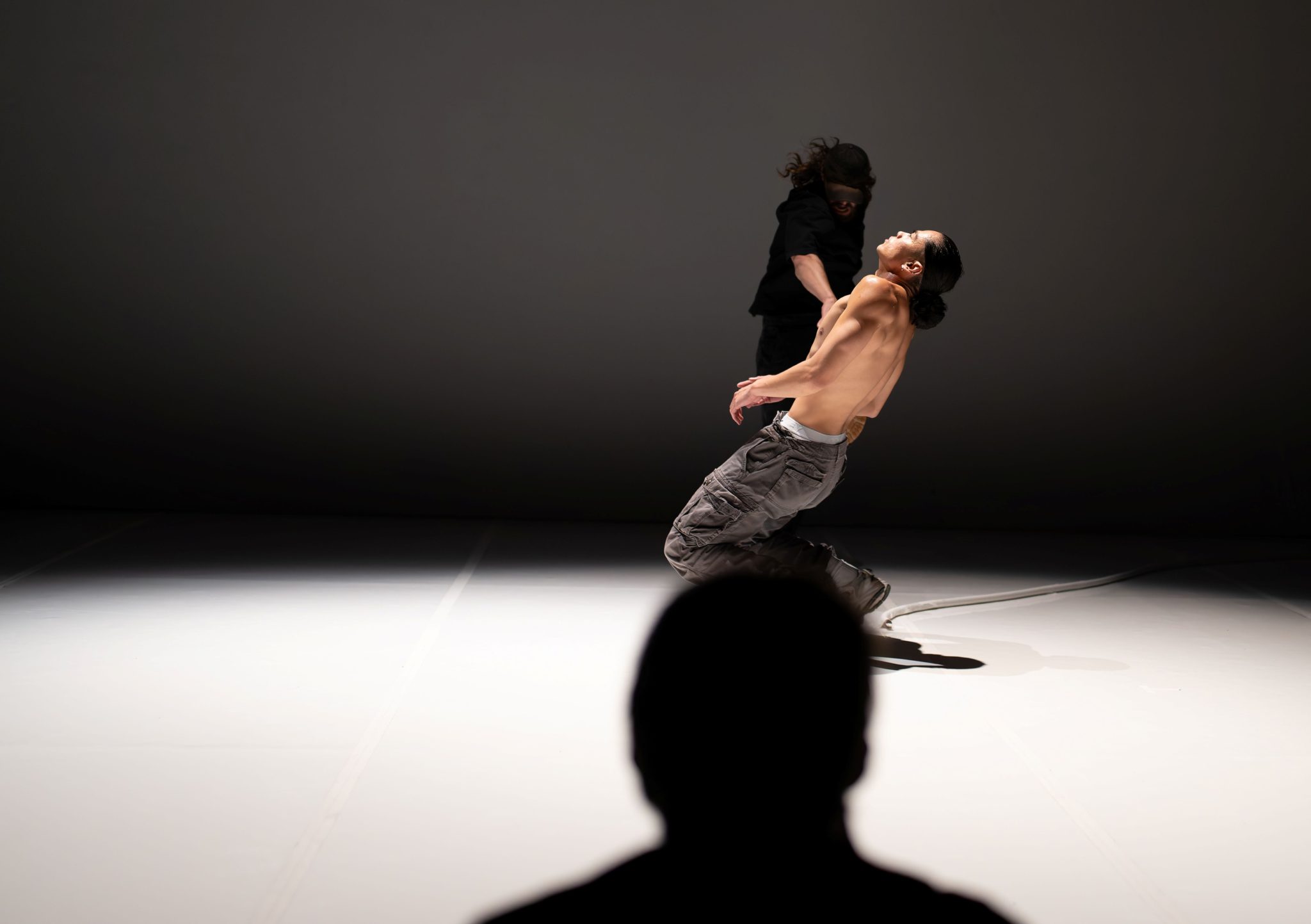 Jobel kneeling on white floor against a dark background