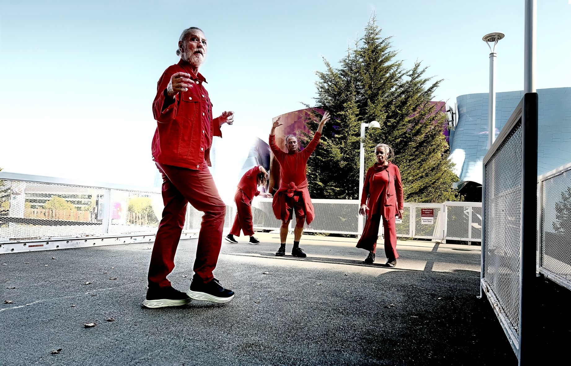 MALACARNE dancers wearing red on the monorail platform