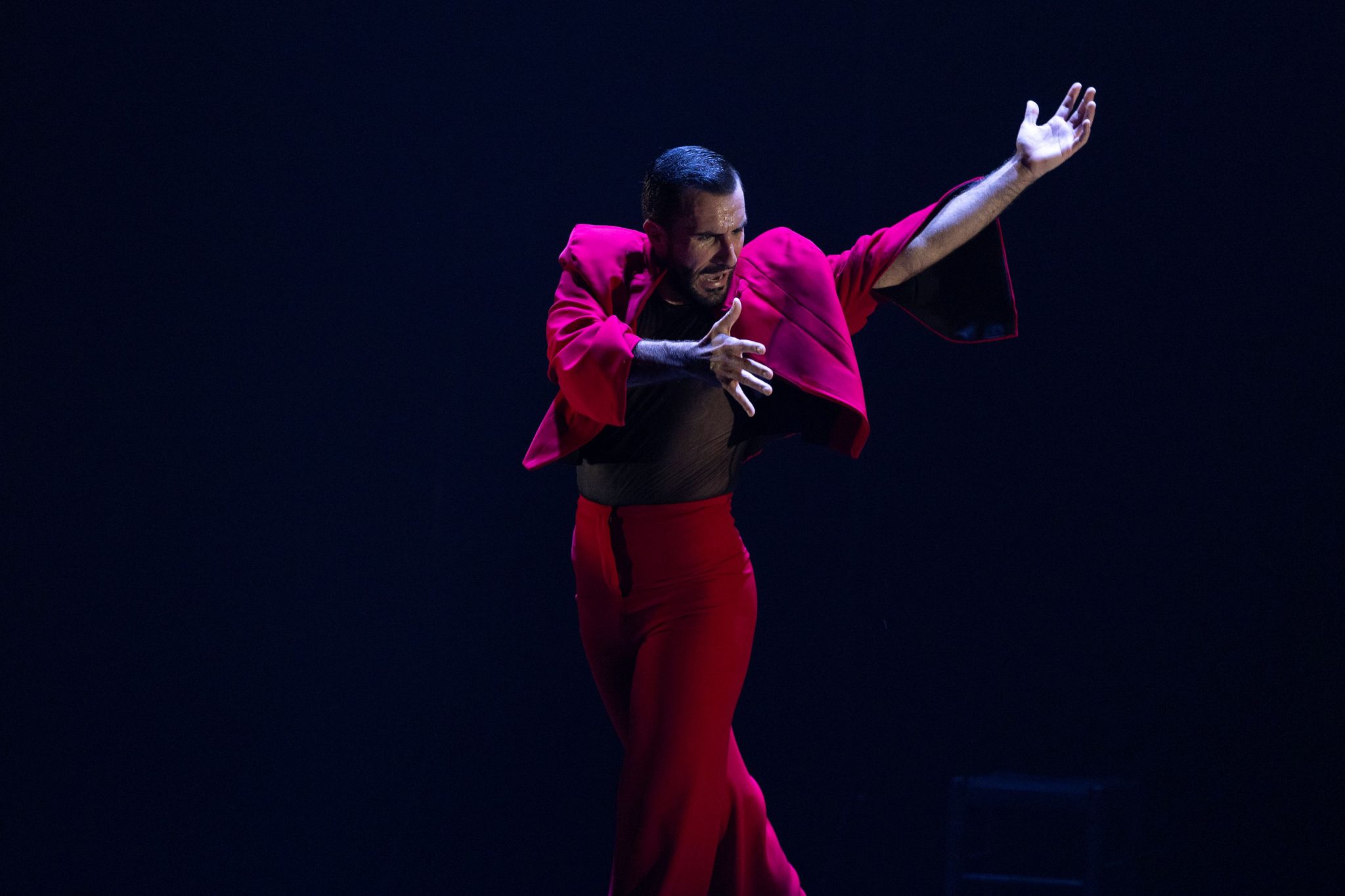 Ramirez wearing pink jacket and pants against a black background